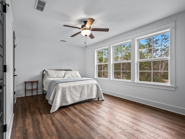 bedroom with ceiling fan, baseboards, visible vents, and wood finished floors