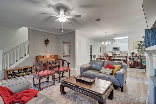 624 W 7th Ave Unit 1And 2, Tallahassee, FL 32303 - living room with stairs, a ceiling fan, light wood-style floors, ornamental molding, and a chandelier