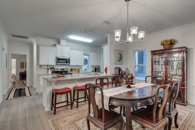 624 W 7th Ave Unit 1And 2, Tallahassee, FL 32303 - dining room featuring a chandelier, crown molding, light wood-style flooring, and plenty of natural light