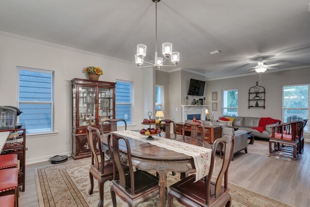 624 W 7th Ave Unit 1And 2, Tallahassee, FL 32303 - dining space with light wood-type flooring, a chandelier, ornamental molding, ceiling fan, and a lit fireplace