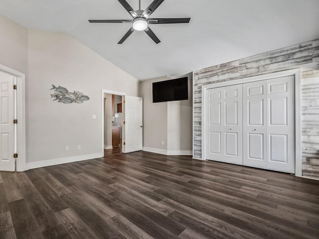 unfurnished bedroom with dark wood-style floors, lofted ceiling, baseboards, and a ceiling fan