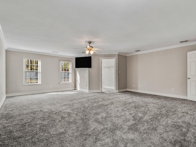 carpeted spare room featuring baseboards, ceiling fan, visible vents, and crown molding