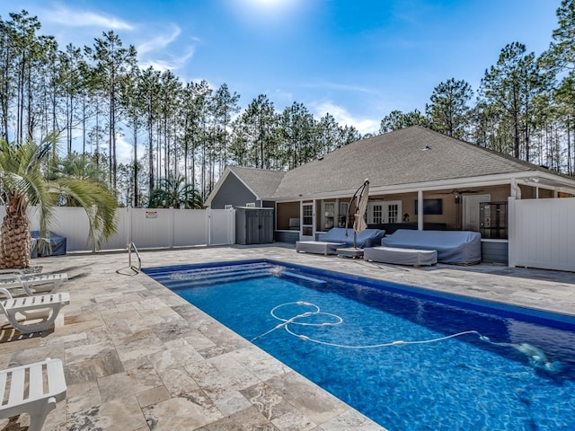 view of swimming pool featuring ceiling fan, a patio, outdoor lounge area, fence, and a fenced in pool