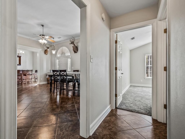 hall featuring dark tile patterned floors, baseboards, visible vents, and a chandelier