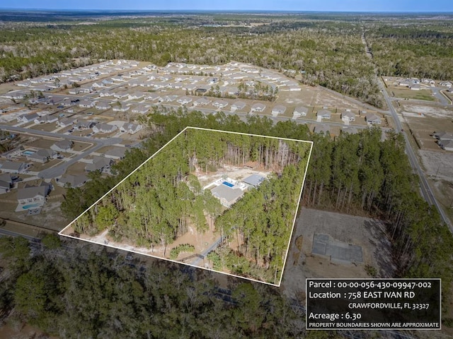 birds eye view of property featuring a wooded view and a residential view