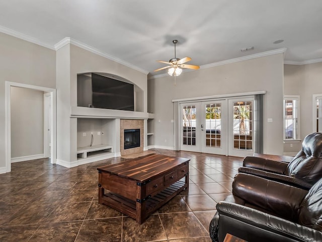 living area featuring ceiling fan, a tile fireplace, visible vents, french doors, and crown molding