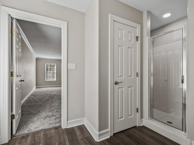 hallway featuring dark wood-style floors and baseboards