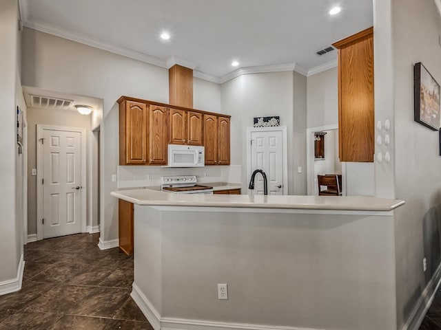 kitchen with a peninsula, white appliances, visible vents, light countertops, and brown cabinetry