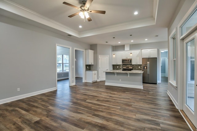 kitchen featuring a center island, white cabinets, hanging light fixtures, dark hardwood / wood-style flooring, and stainless steel appliances