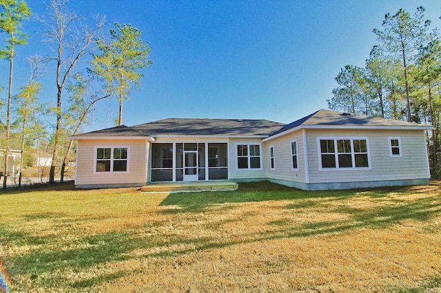 back of property with a sunroom and a yard