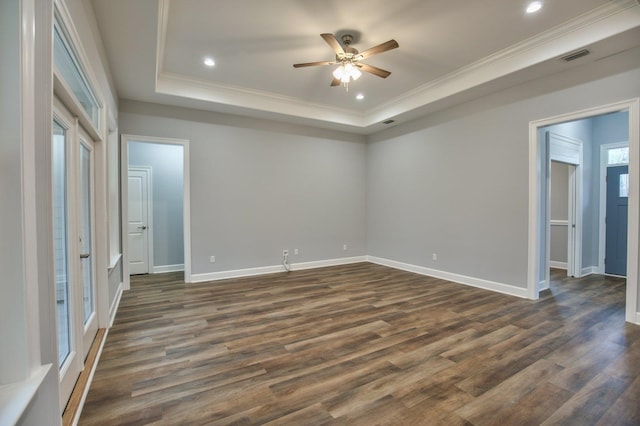 unfurnished bedroom with dark hardwood / wood-style floors, crown molding, ceiling fan, and a tray ceiling