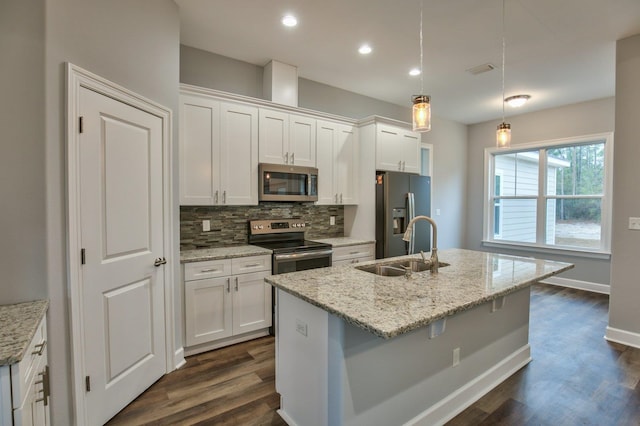 kitchen with pendant lighting, white cabinets, dark hardwood / wood-style floors, an island with sink, and appliances with stainless steel finishes