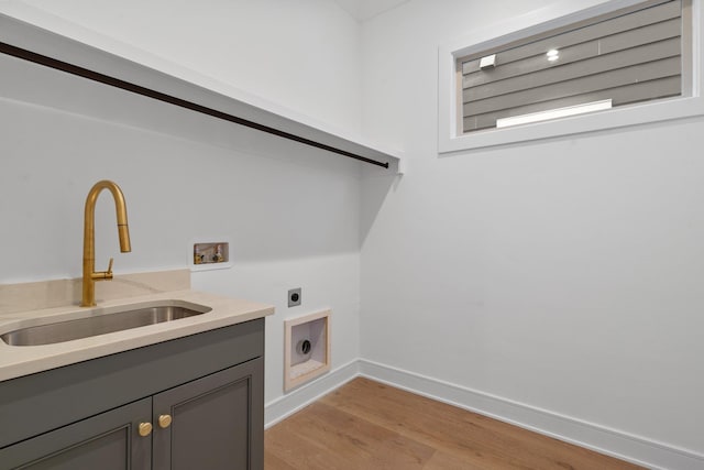 laundry room featuring sink, cabinets, light wood-type flooring, washer hookup, and hookup for an electric dryer