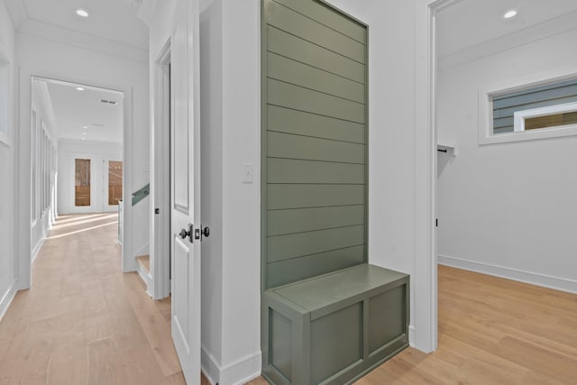 hallway with ornamental molding and light wood-type flooring