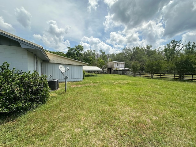 view of yard with cooling unit, a carport, and fence