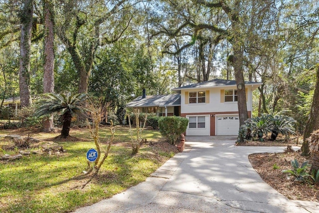 tri-level home with a garage, brick siding, and driveway