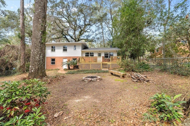 view of yard featuring a fire pit, fence, and a deck