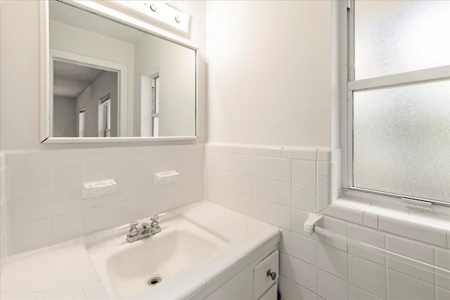 bathroom featuring tile walls, wainscoting, and vanity