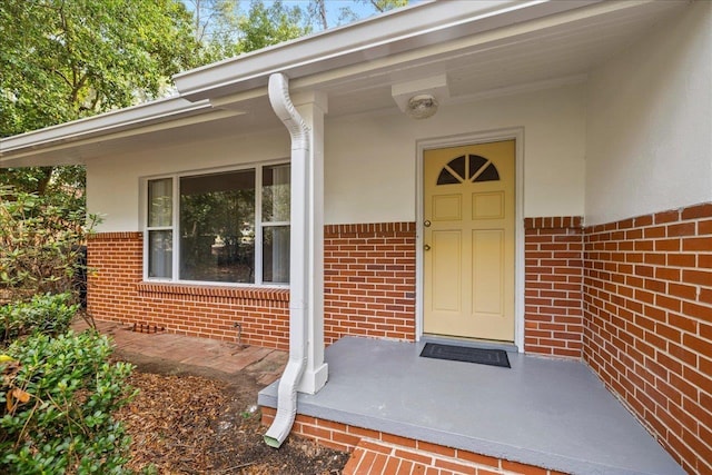 entrance to property featuring brick siding