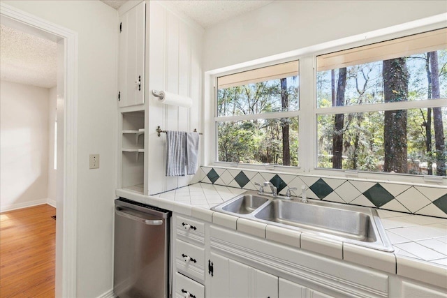 kitchen featuring tile counters, backsplash, and stainless steel dishwasher