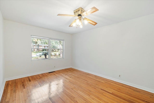 empty room featuring light wood-style floors, baseboards, visible vents, and ceiling fan