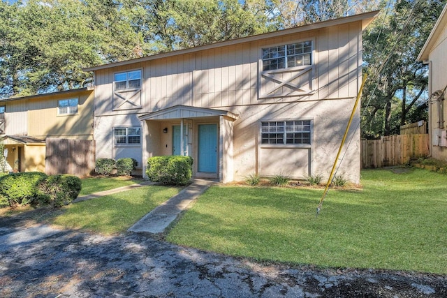 view of front of home featuring fence and a front lawn