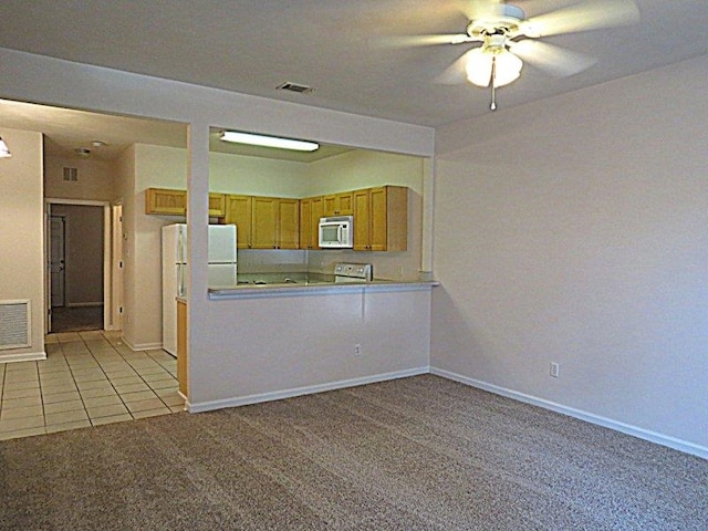 kitchen featuring ceiling fan, white appliances, light colored carpet, and kitchen peninsula