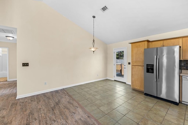 kitchen with dishwasher, tasteful backsplash, stainless steel fridge with ice dispenser, decorative light fixtures, and vaulted ceiling