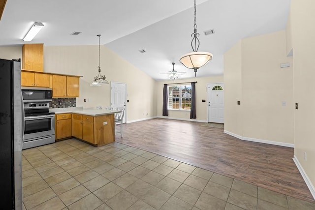 kitchen with stainless steel appliances, tile patterned flooring, pendant lighting, and kitchen peninsula