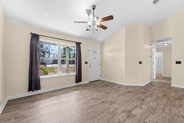 spare room featuring wood-type flooring, lofted ceiling, and ceiling fan