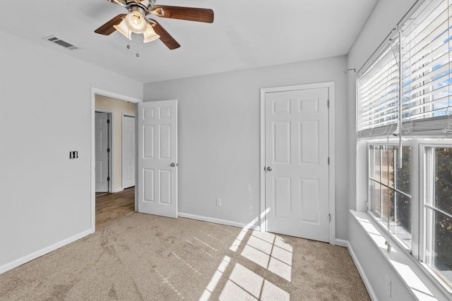 unfurnished bedroom with ceiling fan and light carpet