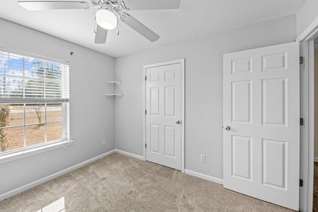 unfurnished bedroom with ceiling fan and light colored carpet