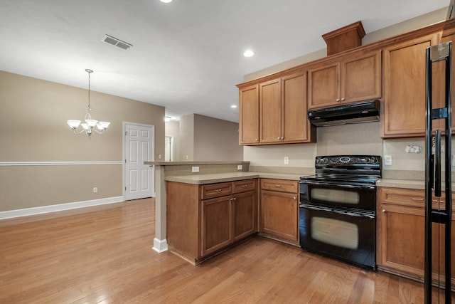 55 Hopkins Landing Rd, Quincy, FL 32351 - kitchen featuring range with two ovens, under cabinet range hood, light countertops, light wood-type flooring, and brown cabinetry