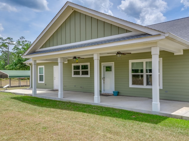 rear view of house featuring ceiling fan and a yard