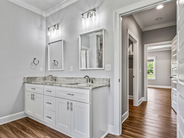 bathroom with wood-type flooring, crown molding, and vanity