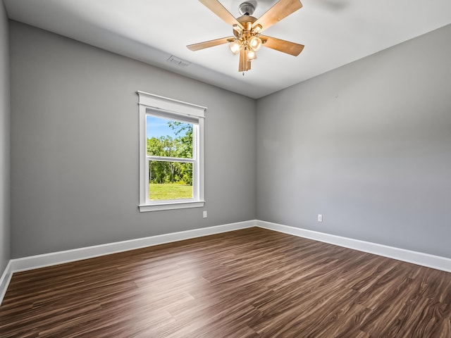 empty room with dark hardwood / wood-style flooring and ceiling fan