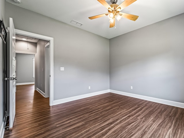 empty room with ceiling fan and dark hardwood / wood-style floors