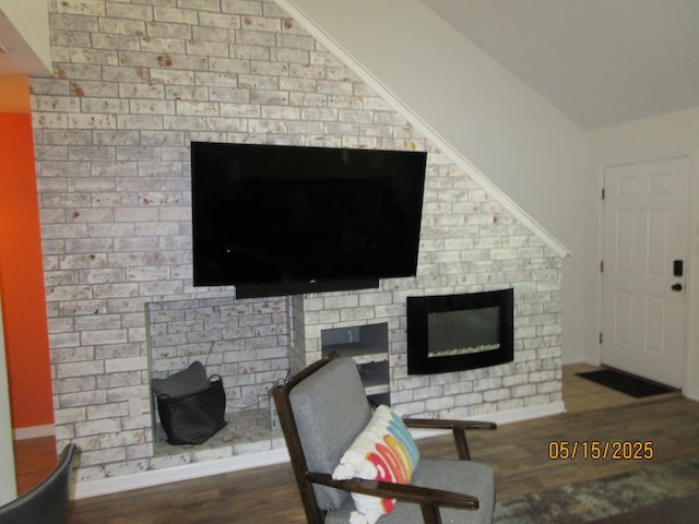 2738 W Tharpe St Unit 2101, Tallahassee, FL 32303 - living area with a glass covered fireplace, wood finished floors, vaulted ceiling, and baseboards