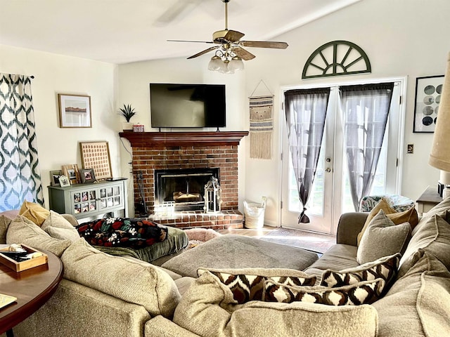 living room featuring ceiling fan, lofted ceiling, and a brick fireplace