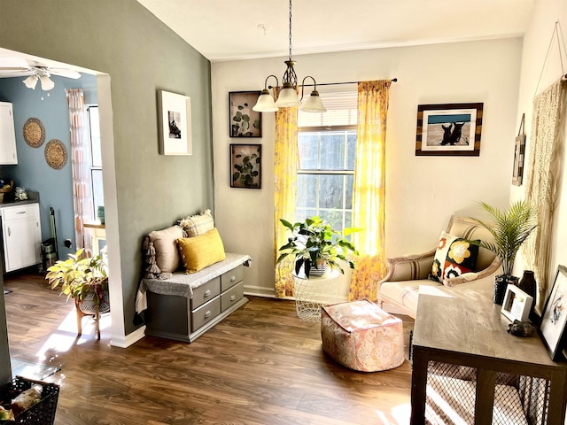 sitting room with dark wood-type flooring and ceiling fan with notable chandelier