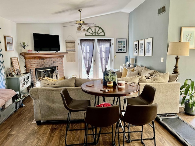 living room with a fireplace, vaulted ceiling, dark hardwood / wood-style floors, and ceiling fan