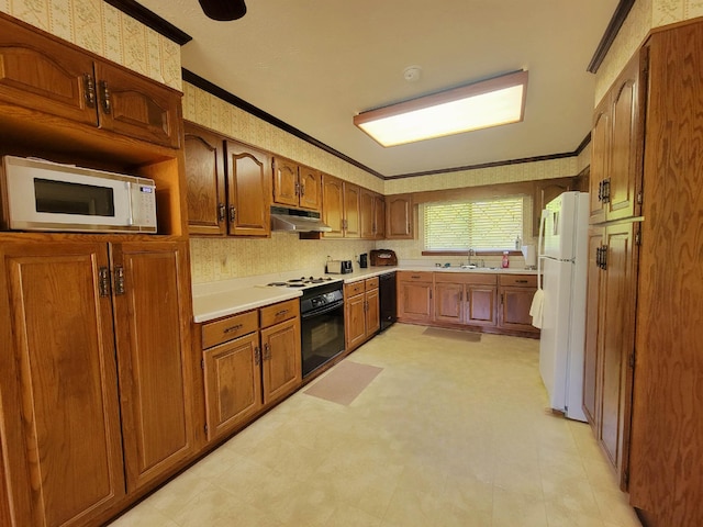 2917 Glover Carlton Rd, Perry, FL 32348 - kitchen with under cabinet range hood, a sink, white appliances, crown molding, and brown cabinetry