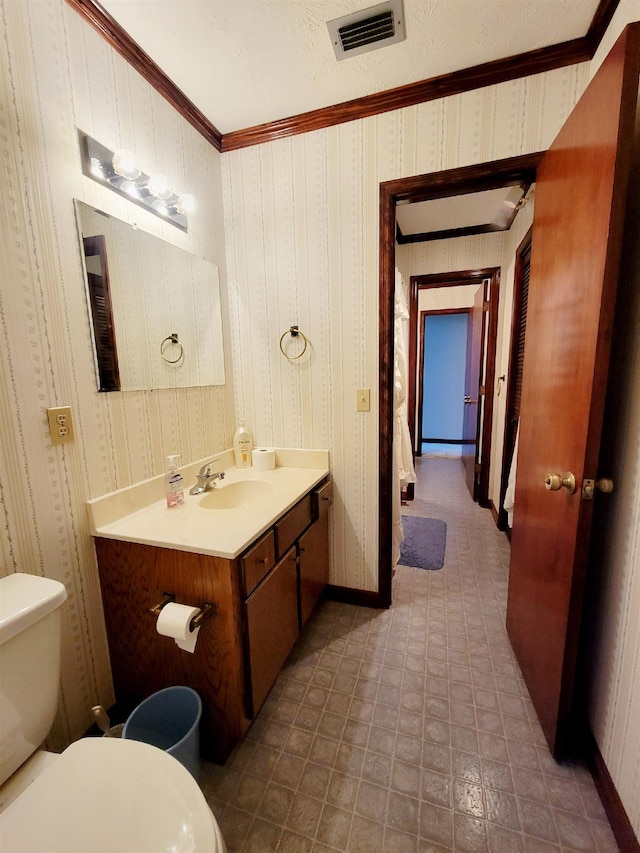 2917 Glover Carlton Rd, Perry, FL 32348 - half bath with toilet, vanity, crown molding, wallpapered walls, and baseboards