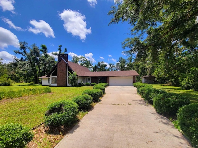 2917 Glover Carlton Rd, Perry, FL 32348 - view of front of property featuring an attached garage, a chimney, concrete driveway, and a front lawn