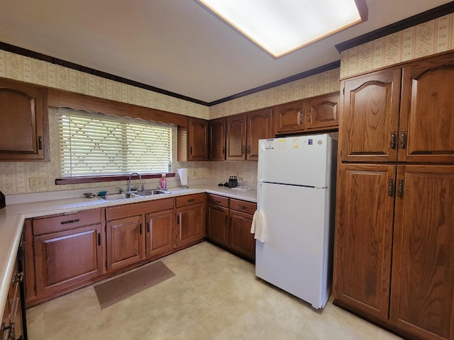 2917 Glover Carlton Rd, Perry, FL 32348 - kitchen with freestanding refrigerator, a sink, wallpapered walls, light countertops, and light flooring