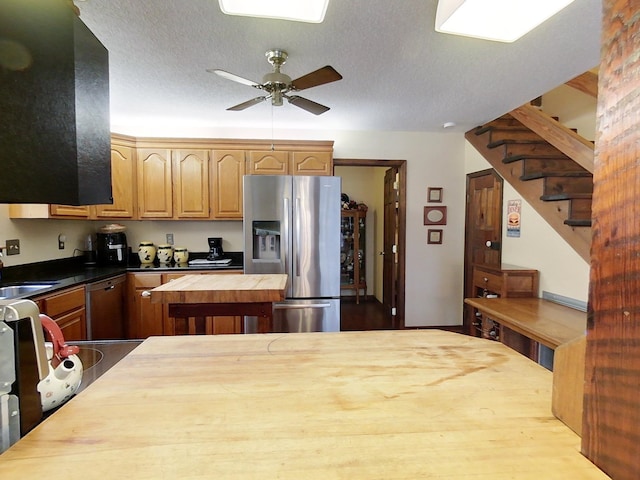 kitchen with a textured ceiling, ceiling fan, butcher block counters, and stainless steel appliances