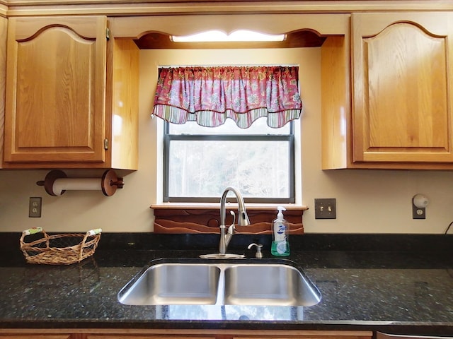 kitchen featuring dark stone countertops and sink