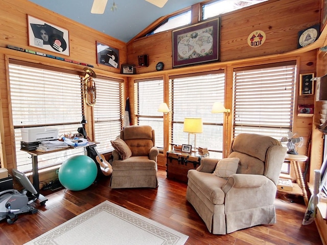 interior space featuring ceiling fan, hardwood / wood-style floors, vaulted ceiling, and wooden walls