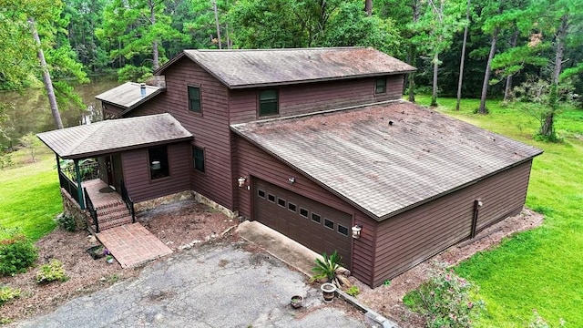 view of front of house featuring covered porch, a garage, and a front lawn