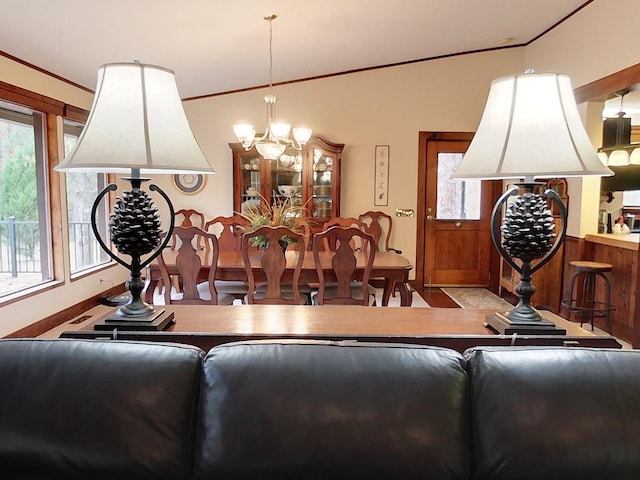 dining space with vaulted ceiling and a notable chandelier